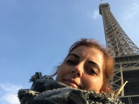 mujer posando para foto con la torre Eiffel detrás