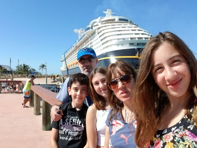 familia haciéndose foto con barco de crucero 